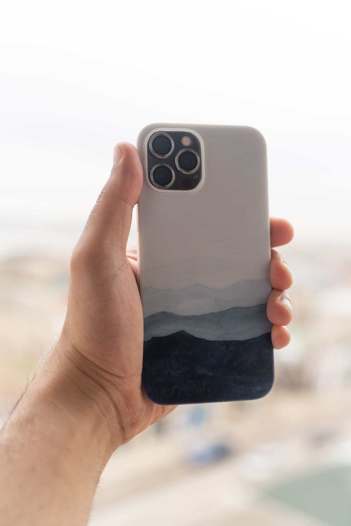 Person holding a smartphone with the back facing outward