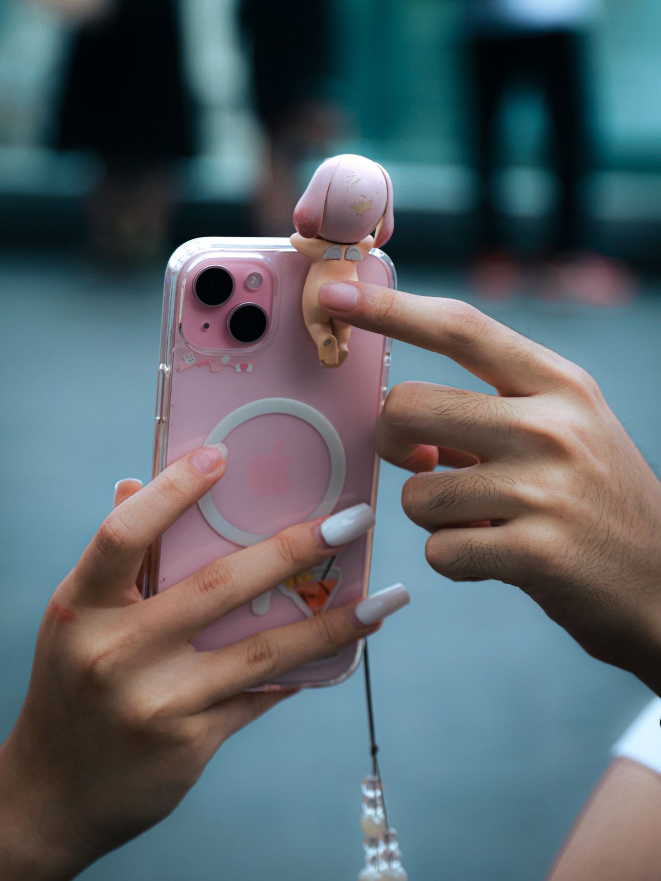 Person holding a phone in a clear case with a finger loop