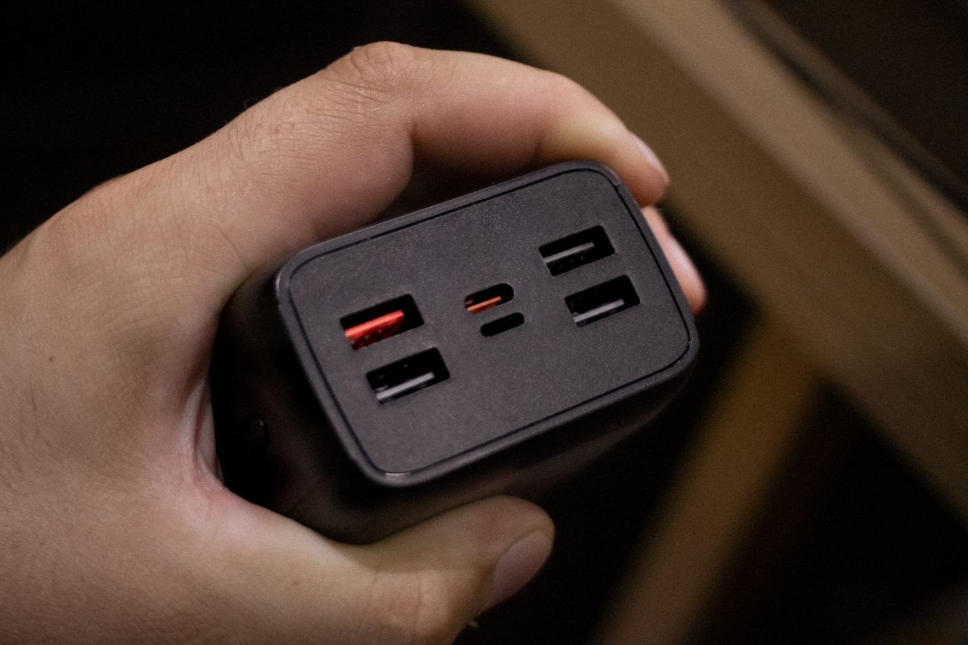 Hand holding a charger with several USB output ports
