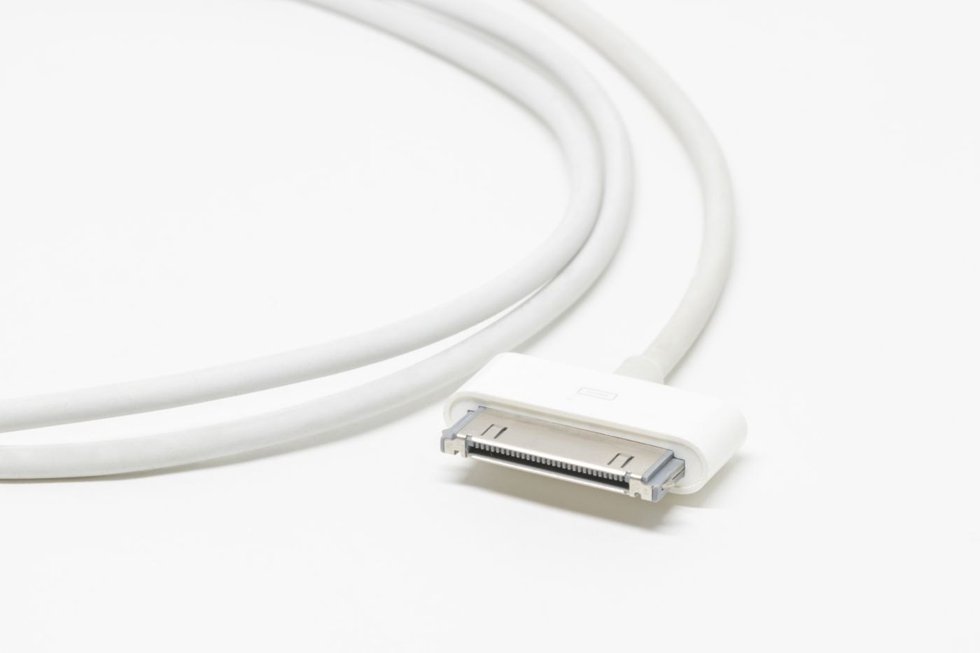 White charging cable curved loosely on a pale surface