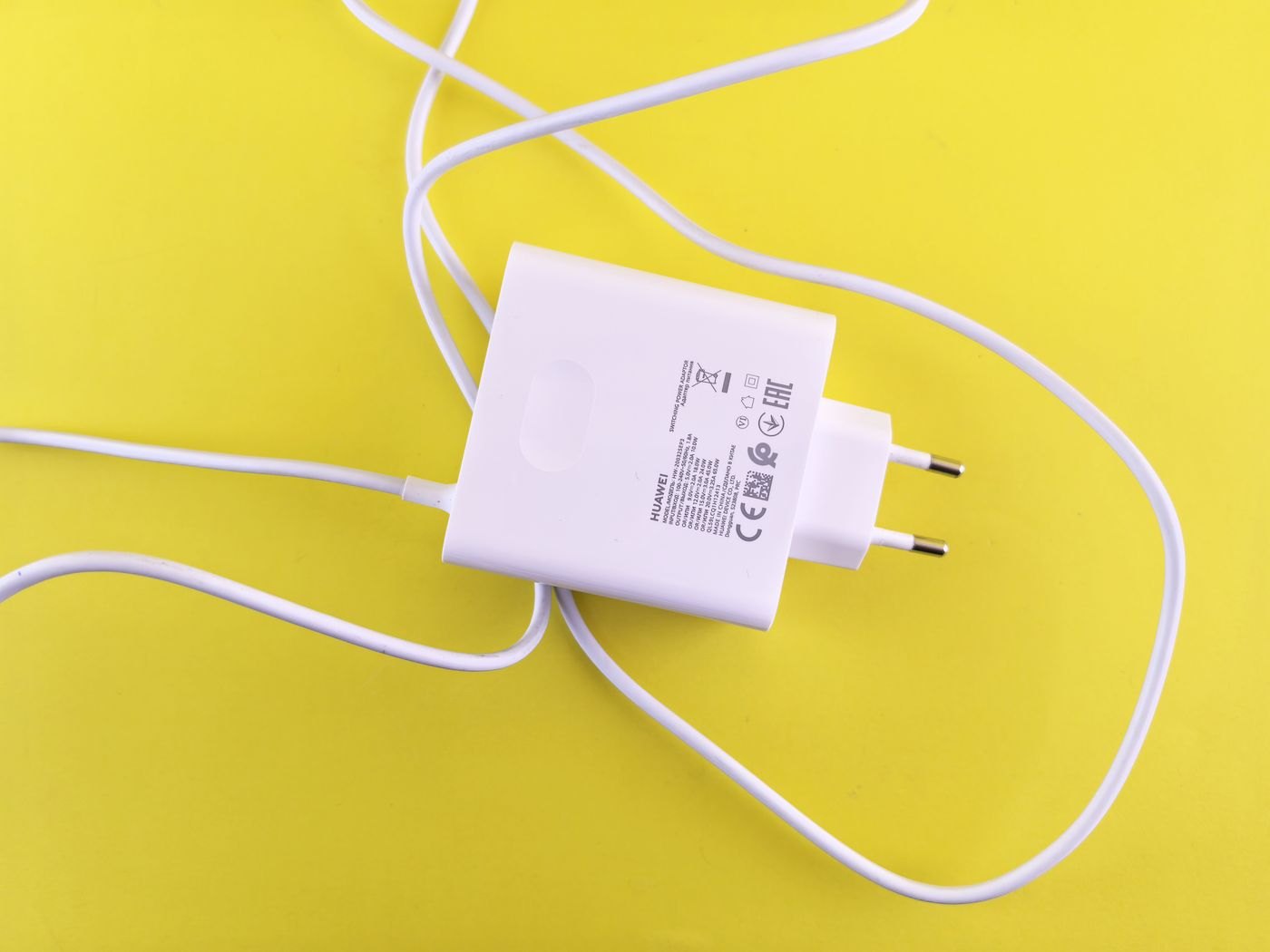 Power adapter label and cable on a yellow surface