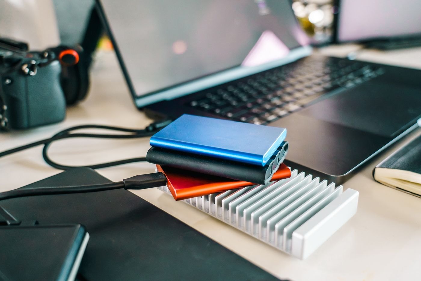 Several external storage drives beside a laptop