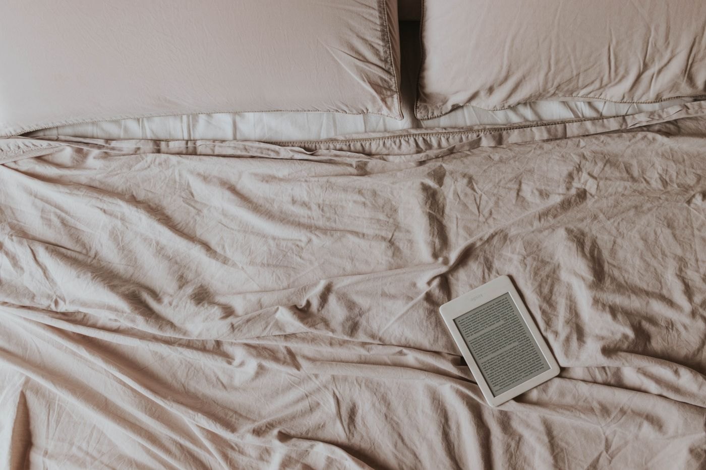 E-reader resting on a neatly arranged bed